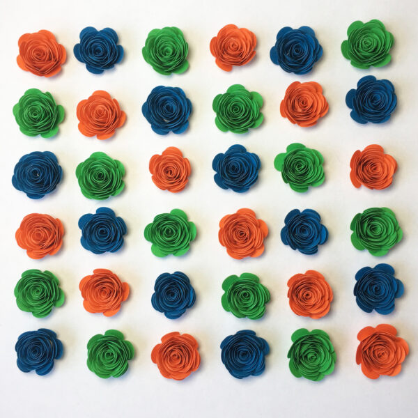 Gerollte Papierblumen in den Farben Orange, Mittelblau und Smaragdgrün, angeordnet in Diagonalen